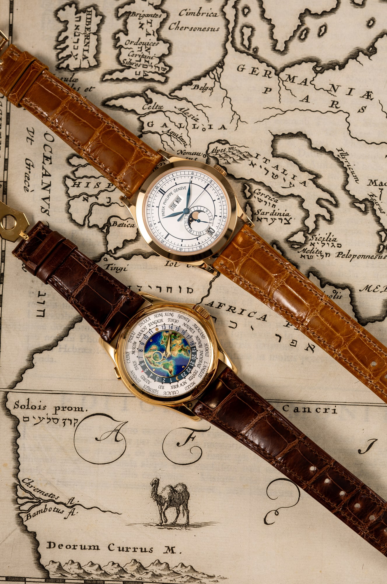 Zwei Armbanduhren von Patek Philippe auf einer alten Landkarte